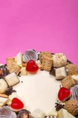 Part of a big festive cake on a pink background, top view.