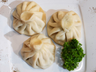 Georgian dumplings Khinkali with meat, greens and tomato spicy sauce.