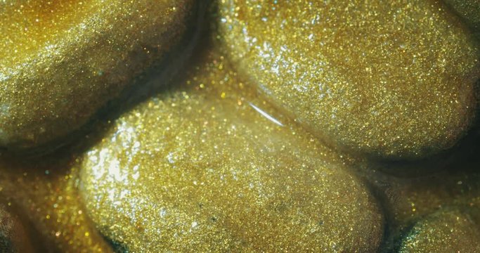 Coffee beans in gold oil.  gold oil paints. Macro. 4K.
