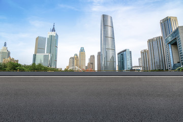 Fototapeta na wymiar The empty asphalt road is built along modern commercial buildings in China's cities.