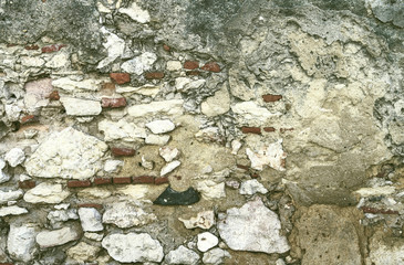Stone wall with fragile plaster as a background.