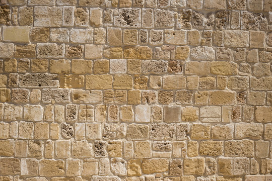 Sandstone, limestone aged wall at Cyprus. Yellow stonewall background, close up view with details.
