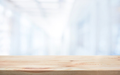 Wood table top on blur white glass wall background form office building