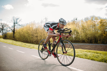 Fototapeta premium Male cyclist rides on bicycle, front view