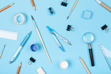 Pattern made of school stationary on blue background. Top view, flat lay.