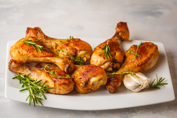 Grilled spicy chicken legs baked with garlic, rosemary and thyme on white background.
