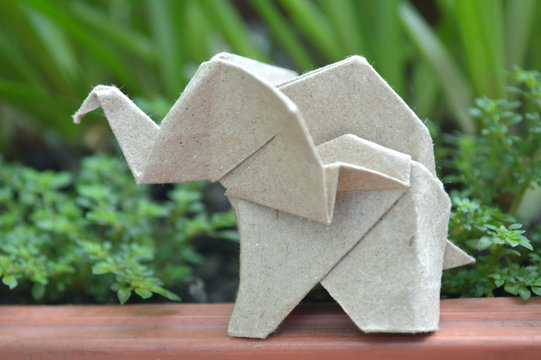 Brown origami elephant on natural background