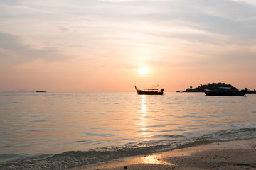 Longtail boats on seashore at sunrise in summer time concept travel, holiday and vacation. Tropical paradise beach nature landscape at Lipe island in Thailand.