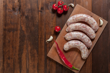 Raw chicken sausages on cutting board