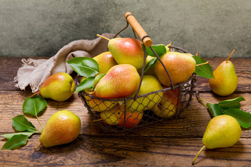 pears with leaves in a basket on wooden table