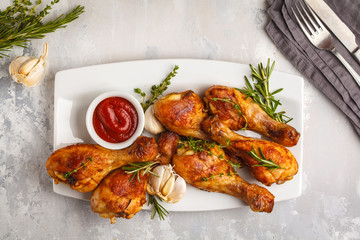 Grilled spicy chicken legs baked with garlic, rosemary and thyme on white background.
