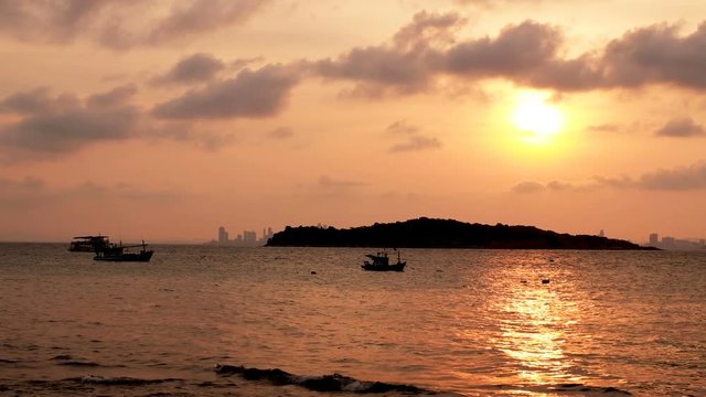 Dramatic seascape sunset orange sky twilight view with silhouette fishing boat from koh larn, pattaya, chon buri, thailand, FHD video with copy space