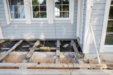 Installing a wood floor outdoor terrace in new house construction site. Scandinavian style