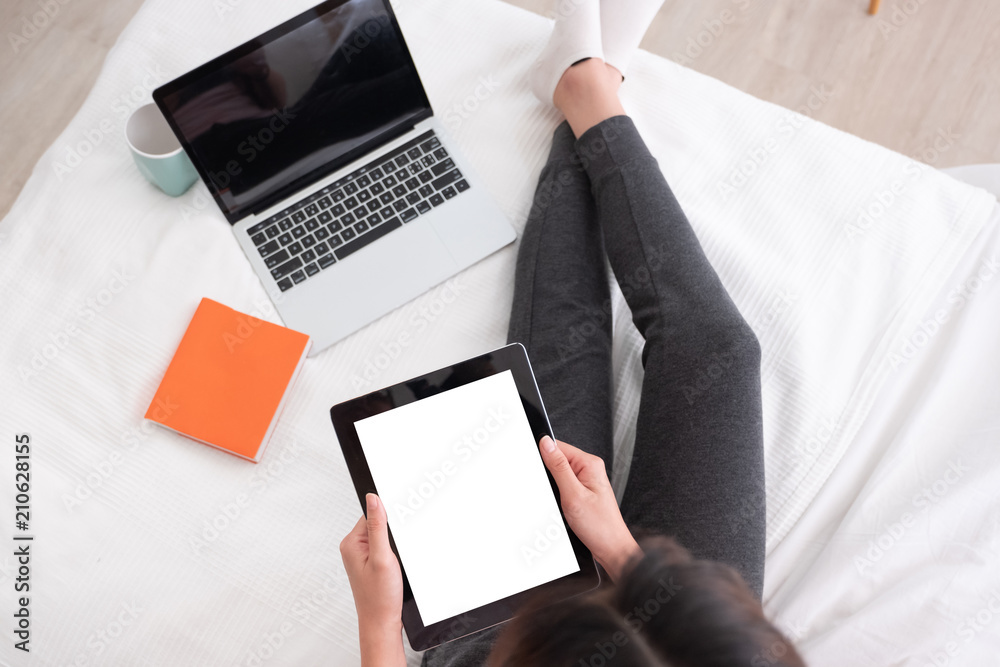Poster top view woman use tablet,laptp working online on bed in bedroom at home.mock up template device scr