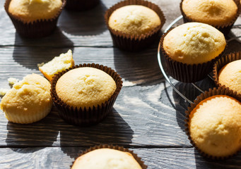 Fragrant vanilla cupcakes in molds on wooden surface
