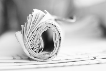 Rolled paper with news on top of pages with headlines and articles, daily newspapers  