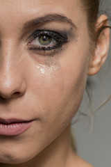 Sad crying girl looking into camera with smeared make-up