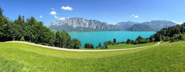 View to lake Attersee with green pasture meadows and Alps mountain range near Nussdorf Salzburg, Austria