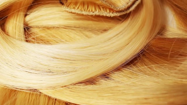 Hair extension cutted hair fibers blonde weft rotating pattern macro texture background backdrop footage video.