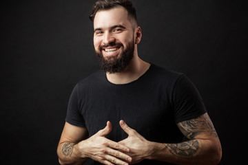 Happy young man. Portrait of handsome young man in casual shirt keeping arms crossed and smiling...