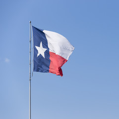 Texas flag waving against blue sky. State Flag of Texas on a Windy Day