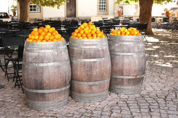 Oranges in vintage barrels on a medieval street in Europe