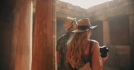 Young tourists couple in Greece taking photos of ancient columns - Powered by Adobe