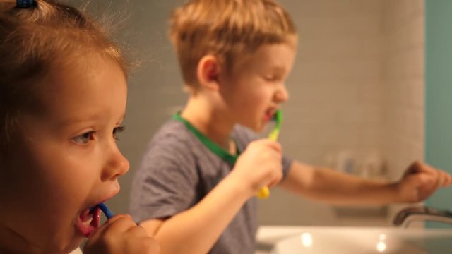 Hygiene of children brother and sister enjoy brushing their teeth in a bathroom at home