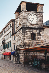 Fototapeta na wymiar Clock tower and old historical buildings in the ancient town Kotor in Montenegro