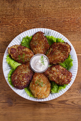 Potato pancakes with sour cream or yogurt. Vegetable fritters, latkes, draniki. View from above, top studio shot