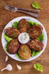 Potato pancakes with sour cream or yogurt. Vegetable fritters, latkes, draniki. View from above, top studio shot