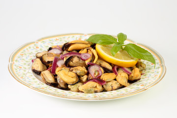 Homemade delicious summer salad with mussels, red onion, olive oil, lemon and basil