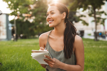 Pretty asian woman holding notebook.