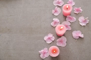  Many Pink hydrangea petals with three candle on gray background © Mee Ting