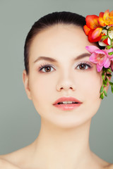 Fototapeta na wymiar Young Perfect Female Face. Spa Woman with Healthy Skin and Flowers
