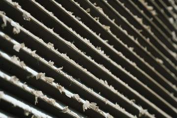 Old metal grating ventilation on the wall of a service room or at home, vintage grunge background.