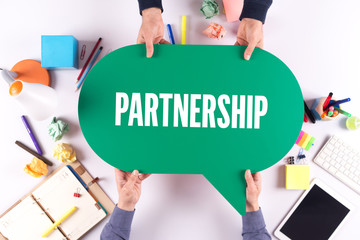 Two people holding speech bubble with PARTNERSHIP concept