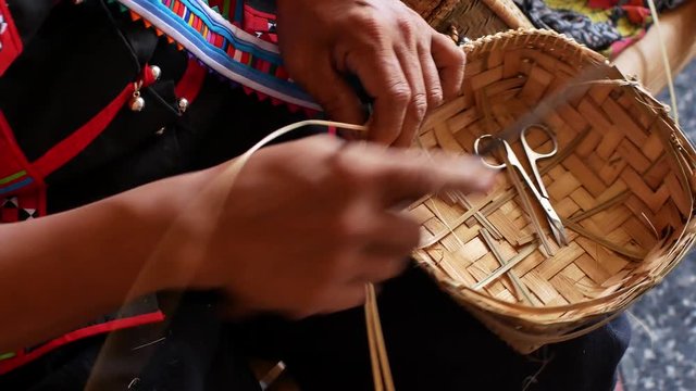 Hand working on bamboo weaving in Thailand.