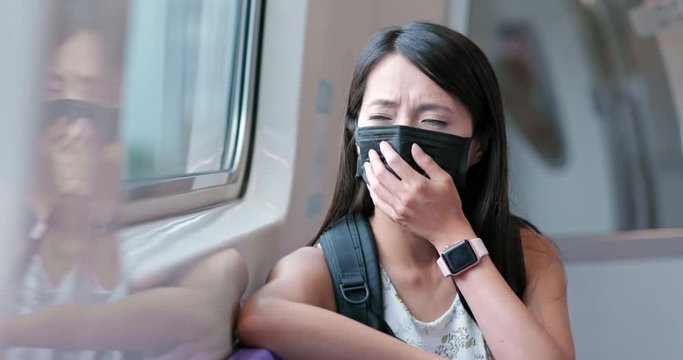 Woman wearing protective mask and taking train