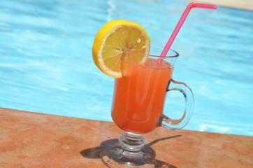 Two Colorful Tropical Cocktails near the Swimming Pool on the Background of Warm Blue Sea. Exotic Summer Vacation.