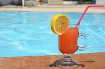 Two Colorful Tropical Cocktails near the Swimming Pool on the Background of Warm Blue Sea. Exotic Summer Vacation.