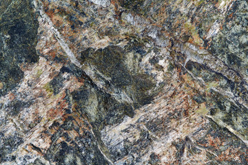 The surface of granite stone with streaks, spots and patterns of different colors. Visible stone texture with thick lines and mottled spots. Colorful background or Wallpaper.
