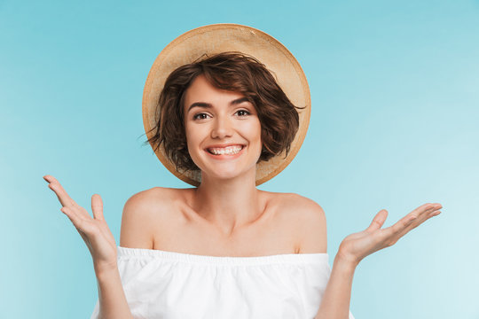 Portrait of a cheerful young woman in summer hat