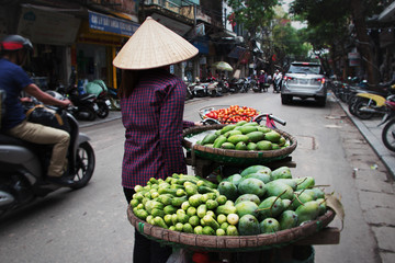 Vendor with bicycle selling tropical fruits at a street in hanoi