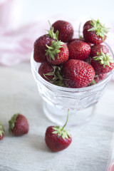 Fresh strawberry fruit in a glass dish . Few strawberries in glass cup