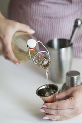 girl pour beverage from bottle into a measuring glass