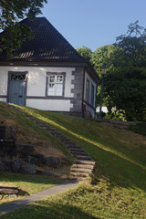 White house stands on a hill with a stone staircase to it