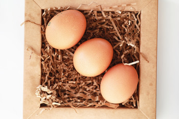 Chicken brown eggs on a white table