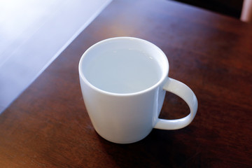 White cup on wood table.