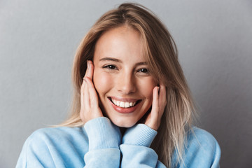 Close up of a smiling young girl in blue sweatshirt
